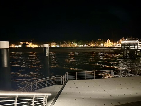 Sicht von einer Brücke auf die Küste mit vielen Lichtern von Häusern