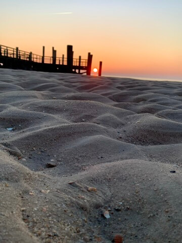 Das Wattenmeer im Hintergrund eine Brücke vor einem Sonneuntergang